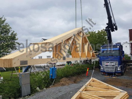 Medinių stogo santvarų montavimas statybvietėje Stogo santvarų montavimas kranu